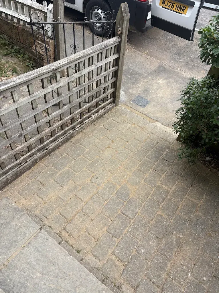 A block paved front path inside a garden gate, before the work