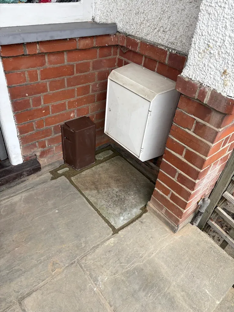 The same corner afterwards, the paving relaid around the meter cabinet and stop tap box